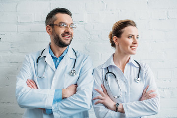 Fototapeta premium doctors with crossed arms standing in front of white brick wall