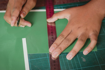 Close-up to hands of students are cutting  prints and stickers