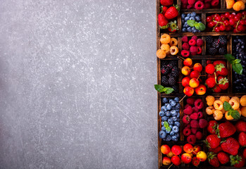 Various fresh summer Berries on the Gray Background. Mix in vintage wooden box.Food or Healthy diet concept.Super Food.Vegetarian.Top View.Copy space for Text.selective focus.