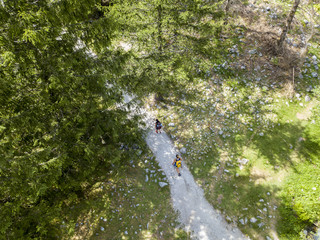 Vista aerea della Val di Mello, una valle verde circondata da montagne di granito e boschi, ribattezzata la Yosemite Valley italiana. Persone su un sentiero. Val Masino, Valtellina, Sondrio. Italia