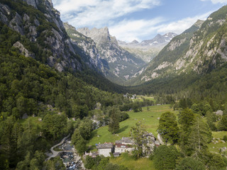 Vista aerea della Val di Mello, una valle verde circondata da montagne di granito e boschi,...