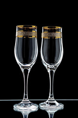a few glasses of wine with a gold rim  on a black background (isolate).