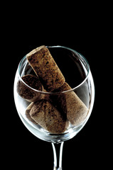 a glass of wine with plugs inside close-up. the glass is on a black background (isolate).