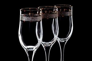 a few glasses of wine with a gold rim close-up on a black background (isolate).