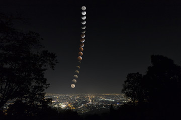 Lunar eclipse and trails phase over Chiang Mai city. Blood Moon in the lunar eclipse and also a Blue Moon and super moon called Super Blue Blood Moon