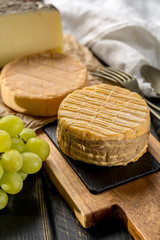 Tasting of oldest french AOC soft pudgent yellow cheese Livarot,  Munster and semifirm Tomme french cheeses
