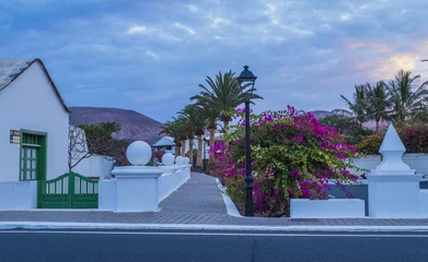 Deurstickers Small village Yaiza in Lanzarote island, white houses and palms at volcatic background. Canary islands, Spain © vitaprague