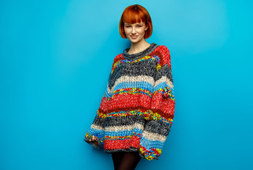 Colorful photo of young female model wear oversize sweater isolated on blue background