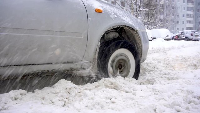 car's wheel being stuck in snow, and spinning.