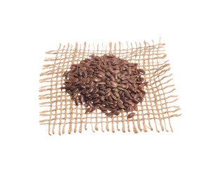 Brown Flax Seed. Grains over hessian fabric, isolated white background.