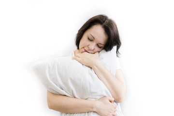 Fototapeta premium Young woman sitting on bed, hugging pillow, smiling. on white background. a girl can't Wake up