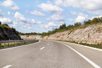 Scenic view on highway road leading through in Istria, Croatia, Europe / Beautiful natural environment, sky and clouds in background / Transport and traffic infrastructure / Road signs and signaling.