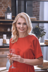 beautiful woman holding glass of wine and looking at camera