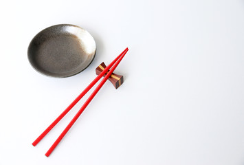 red chopsticks and Ceramic plate White background Copy space