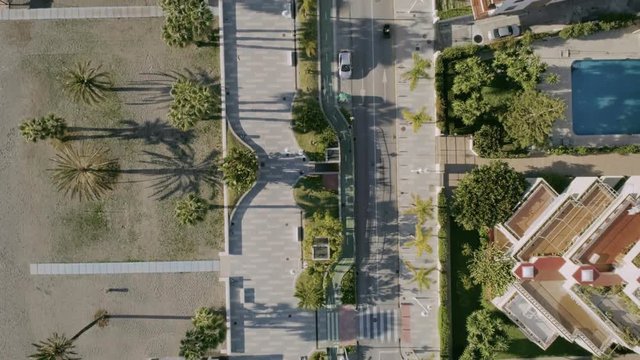 Epic and minimalistic shot from drone on aerial perspective from bird's eye view of suburban neighbourhood in outskirts of town, with apartment buildings and swimming pools