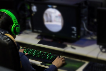 Stressed gamer while playing computer games until morning at internet cafe, game addiction concept, gamer lifestyle