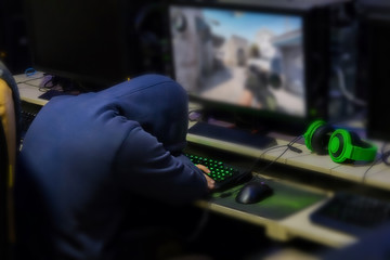 Tried gamer Sleeping in front of games monitor at internet cafe, game addiction concept, gamer lifestyle.