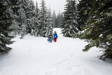 Two snowboarders rises up the mountain slope