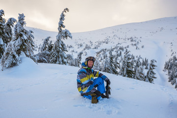 Fototapeta na wymiar Snowboarder resting during a freeride