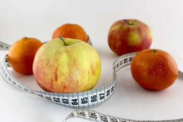 Apples and tangerines, centimeter on a white background