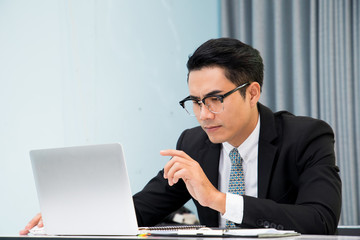 Business man working at office with laptop and documents on his desk