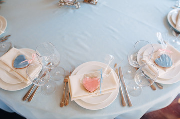 White plates on blue tablecloth, pink and blue heart form cookies on plates
