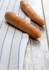 Two carrots on white striped blue cloth