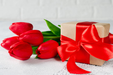Spring bouquet of red tulips and gift box.