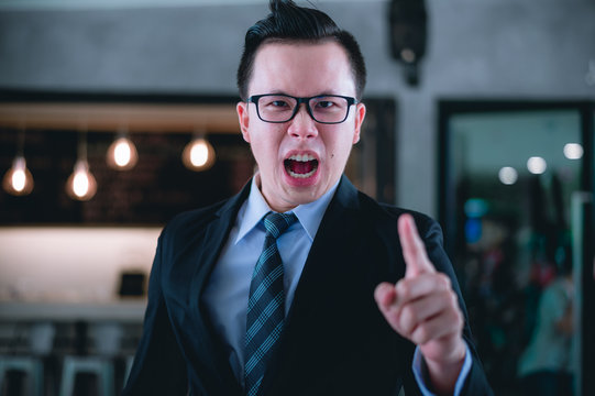businessman shouting and pointing finger at you because he is very angry from Sales reports and financial reports decreased.
