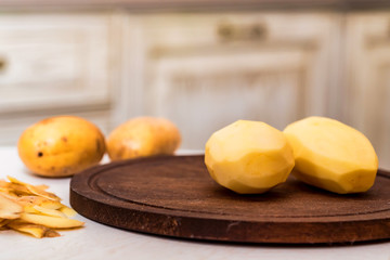 Raw potatoes and peels on table close