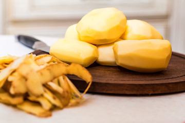 Raw potatoes and peels on table close