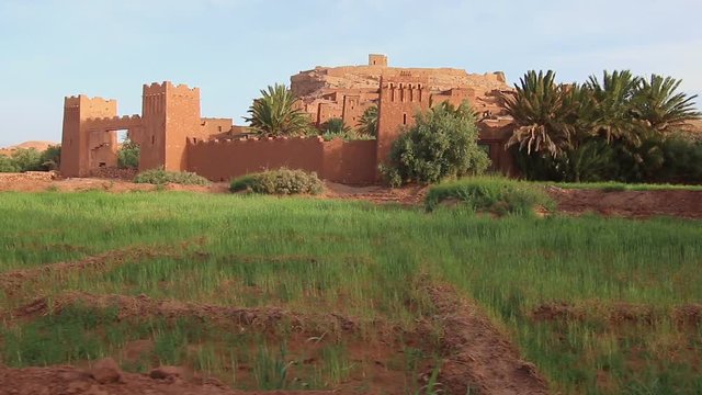 Personal view of walking in African desert scenic city close to water oasis. Old town of Ait-Ben-Haddou Castle in Morocco, exterior in movie Game of Thrones, Steady cam shot