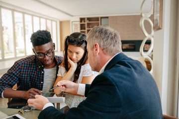 Realtor explaining details of mortgage to couple