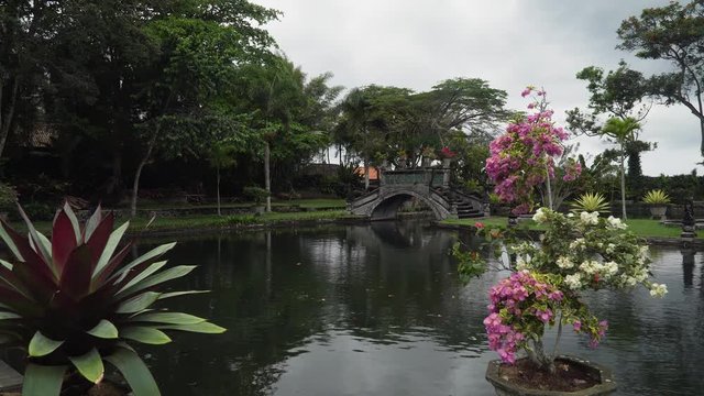 Hindu Balinese Water Palace Tirta Gangga with old bridge on Bali island, Indonesia. Tirta Gangga the former royal water palace is a maze of pools and fountains surrounded by a lush garden and stone