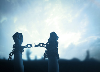 Individual human right day concept: Silhouette human hands raising and broken chains at night...