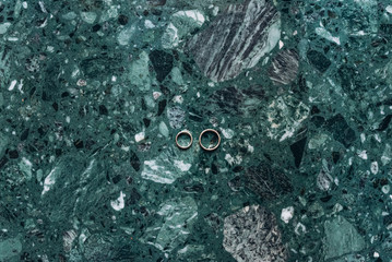 Wedding rings on cool marble mint background