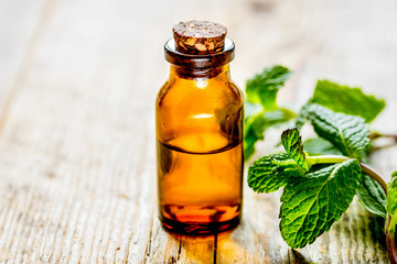 organic cosmetics with herbal extracts of mint on wooden backgro
