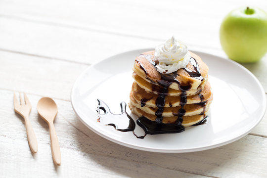 Delicious pancakes with apple on white  wooden table top view