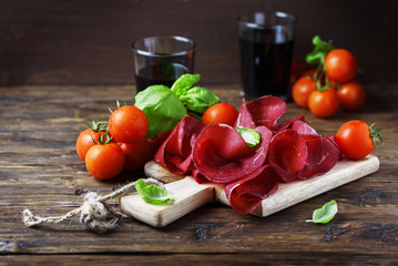 Dish of italian traditional bresaola with red wine