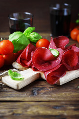 Dish of italian traditional bresaola with red wine
