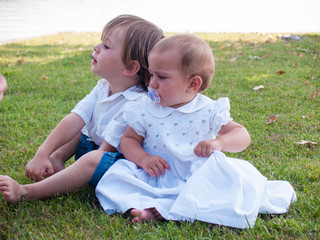 couple of male and female children in green meadow portrait
