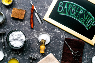 Tools for shaving in barbershop on workplace background top view