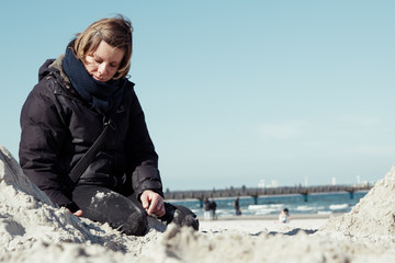 Frau spielt im Winter am Strand