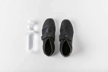 top view of water bottle and sneakers on white surface