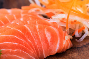 Salmon sashimi in wooden bowl on the table.
