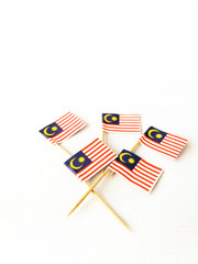 Fototapeta na wymiar Set of toothpick with a small paper flag of Malaysia. Lined up and decorated on isolated white background. Bendera Malaysia, Flag.