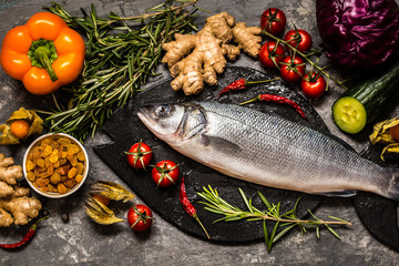 Fish, sea bass and ingredients for cooking: vegetables, spices, herbs