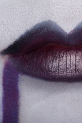 Close up of beautiful full woman lips with purple makeup