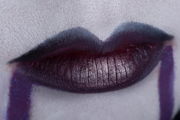 Close up of beautiful full woman lips with purple makeup