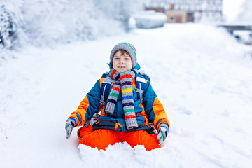 Fototapeta na wymiar Happy kid boy having fun with snow on way to school